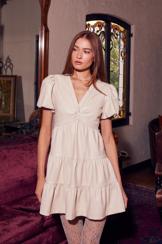 The Selene mini dress combines edgy faux leather with a flattering twisted front for a bold yet feminine look.