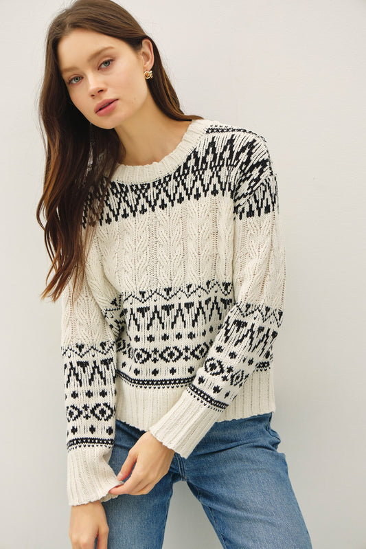 A cozy Fair Isle sweater with cable knit texture and a relaxed, oversized fit — the perfect blend of comfort and charm.