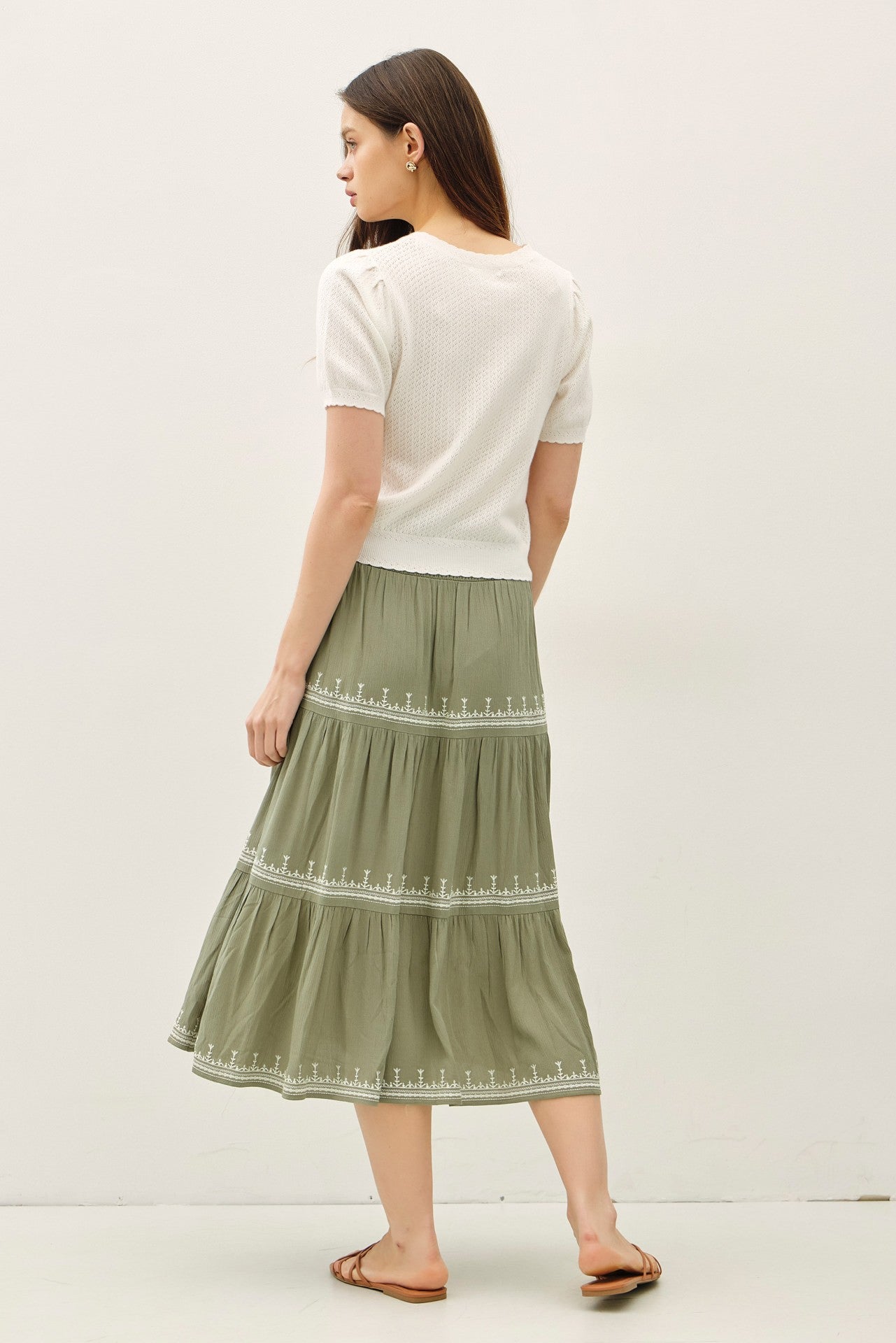 Lightweight pointelle short sleeve cardigan with scalloped edges and button front.