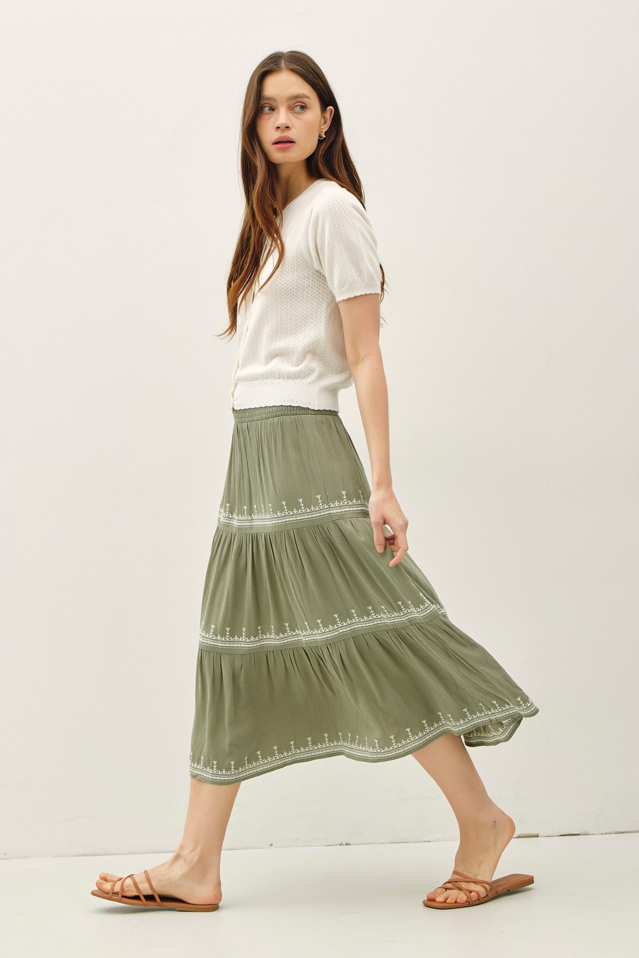 Lightweight pointelle short sleeve cardigan with scalloped edges and button front.