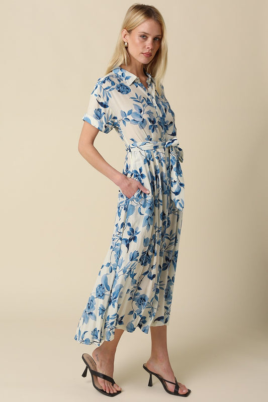 Blue floral belted maxi dress with collared button-down front, short rolled sleeves, and adjustable waist tie.