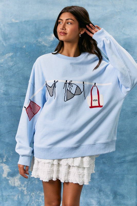 light blue cotton sweatshirt featuring playful summer bathing suit graphics