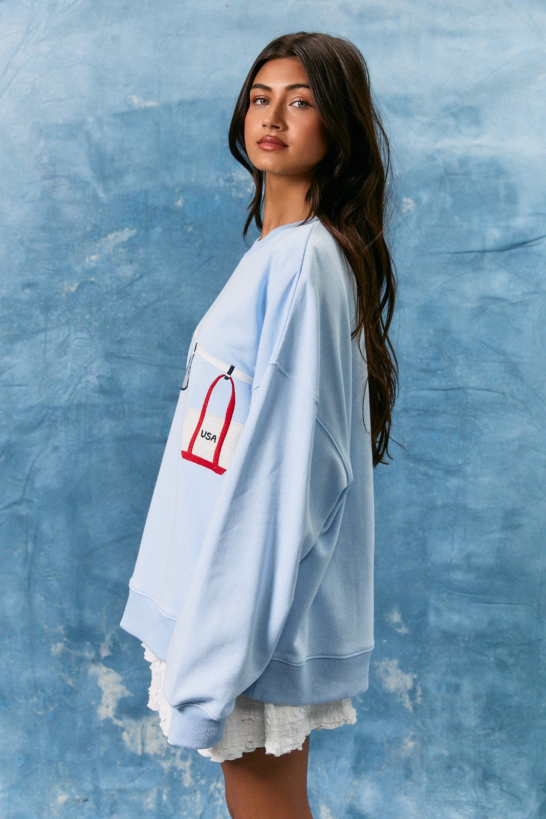 light blue cotton sweatshirt featuring playful summer bathing suit graphics
