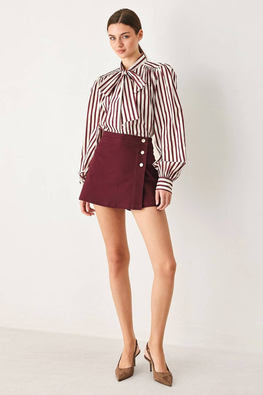 Tailored woven skort featuring a front closure, button detailing, and a flattering silhouette with built-in shorts for comfortable everyday wear.