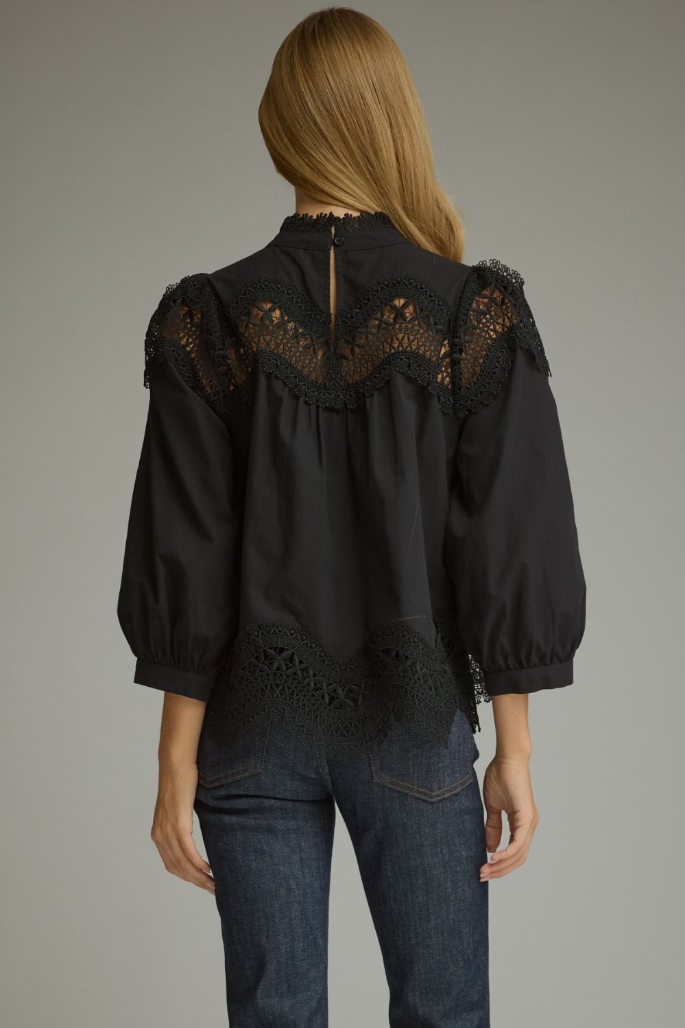 A romantic ¾ sleeve top featuring elegant pintuck detailing, delicate lace trim, and a refined mock neckline.