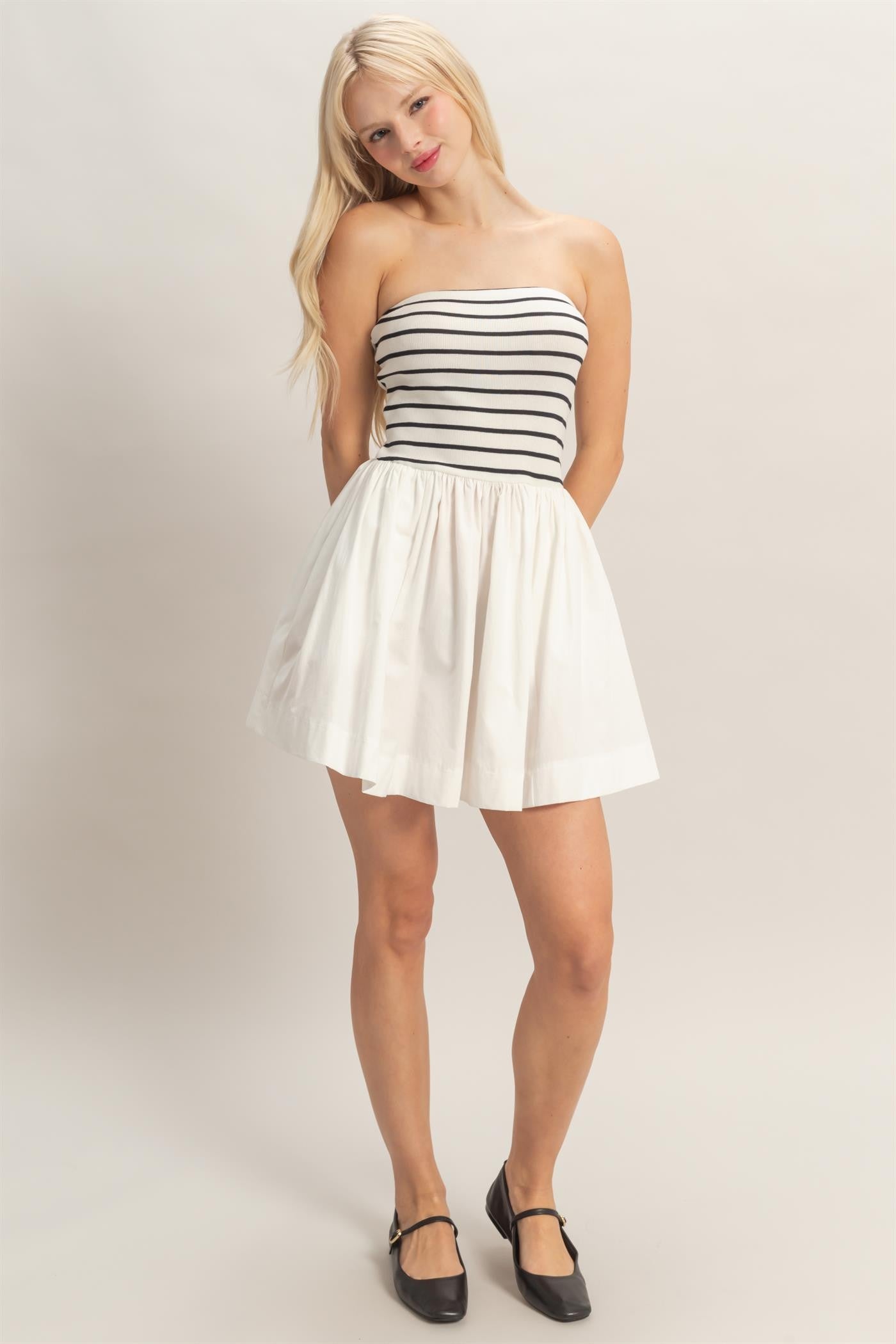 strapless striped mini dress featuring a fitted knit bodice and flowy woven skirt