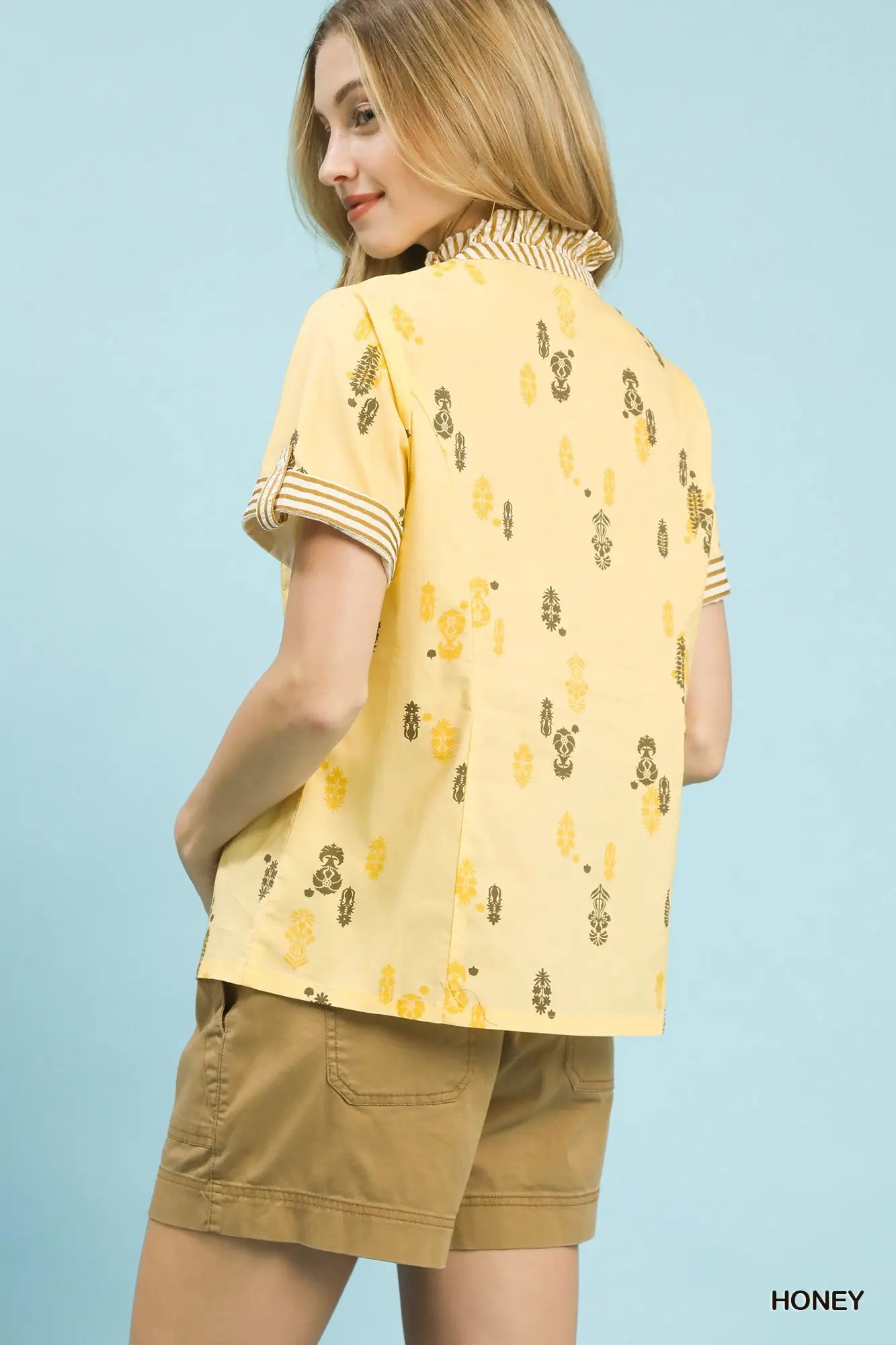 printed cotton blouse featuring a ruffled stand collar and striped ruffle trim accents.