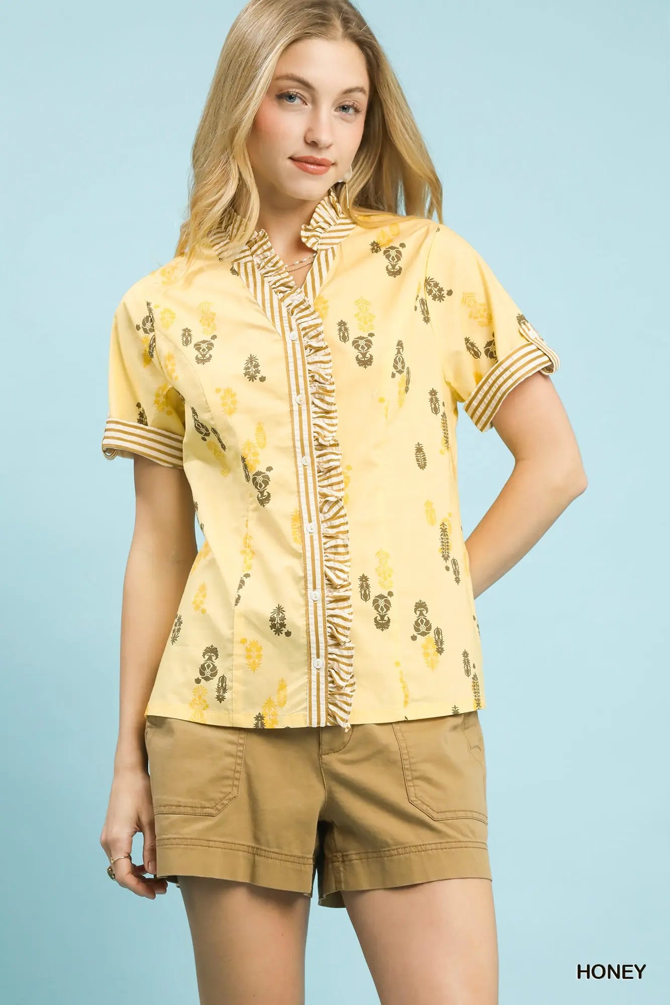 printed cotton blouse featuring a ruffled stand collar and striped ruffle trim accents.