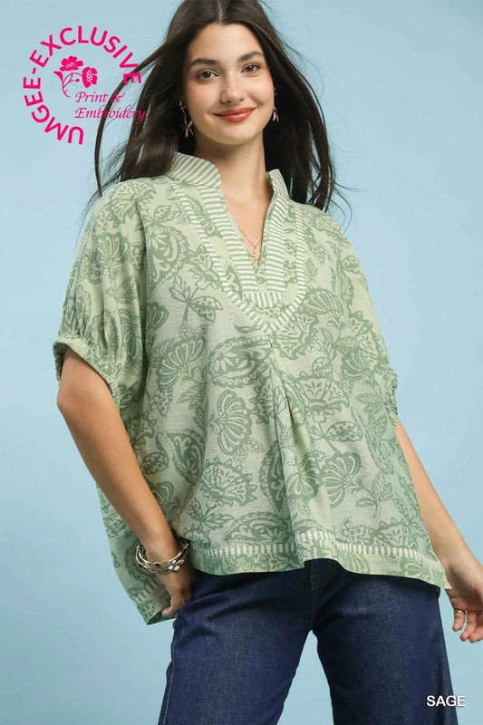 oversized botanical print tunic featuring contrast trim and relaxed dolman sleeves.