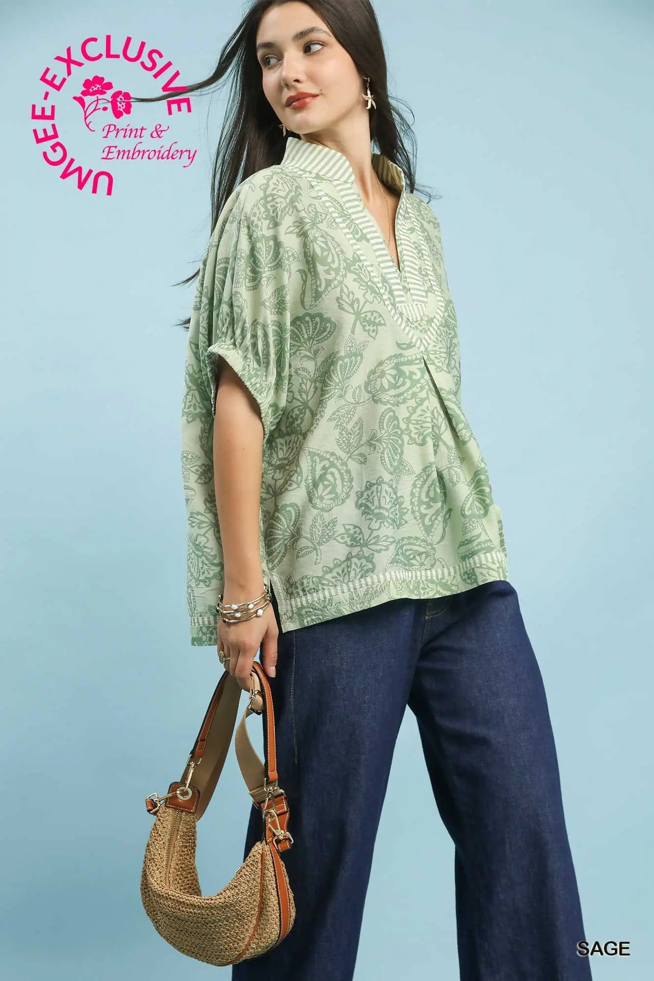 oversized botanical print tunic featuring contrast trim and relaxed dolman sleeves.