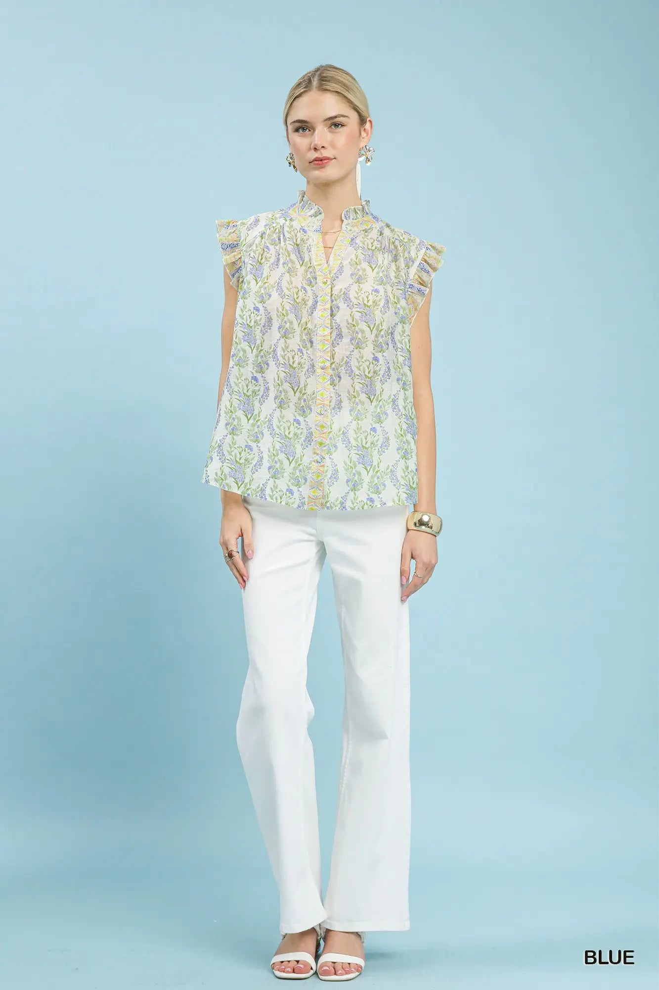 lightweight floral top featuring flutter cap sleeves, a ruffled split neckline, and contrast trim accents