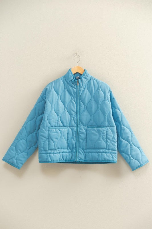 The Evadne Quilted Drawstring Jacket delivers cozy structure with a modern relaxed fit.