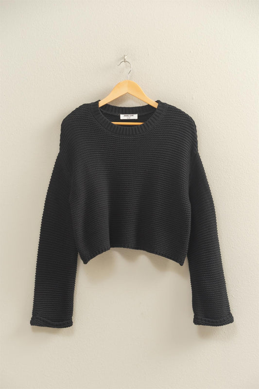 An effortlessly chic textured knit sweater with wide sleeves and a relaxed silhouette for versatile styling.