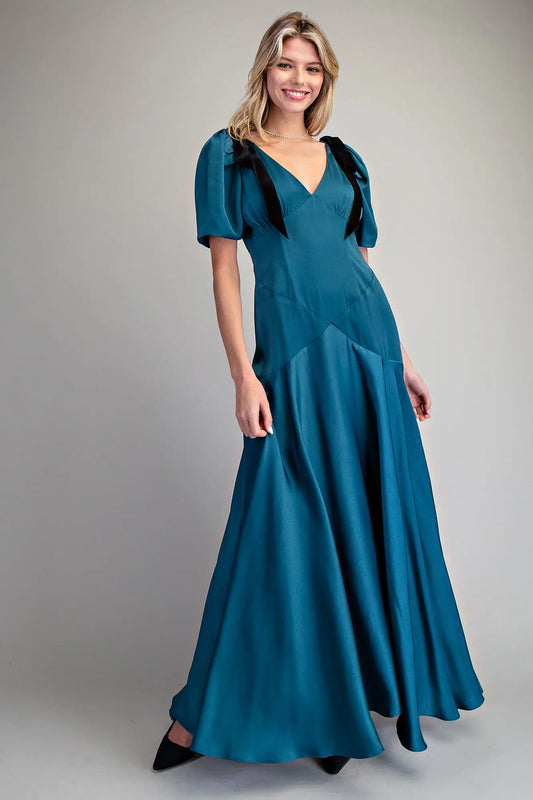 A romantic satin maxi dress with velvet bow tie sleeves, a plunging V-neckline, and a flowing A-line skirt.