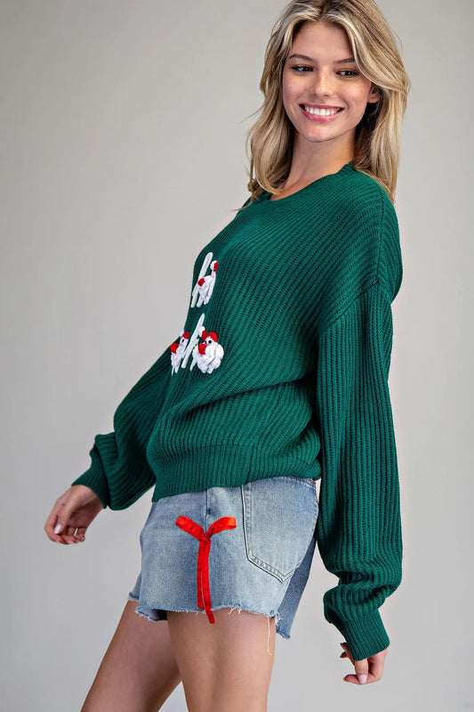 A cozy holiday sweater with playful 3D crocheted Santa appliques and festive “ho ho ho” lettering. 🎅✨