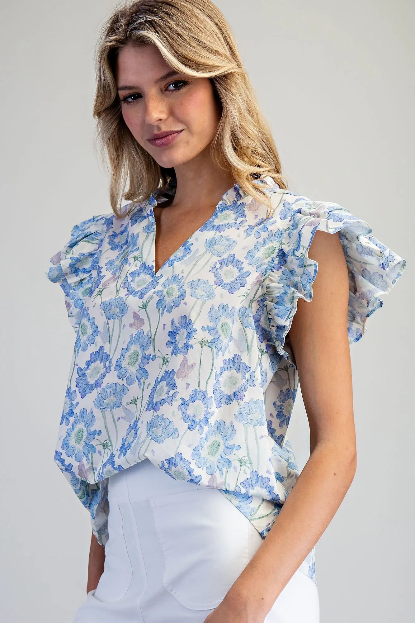 floral cotton top featuring layered flutter sleeves and delicate ruffle trim