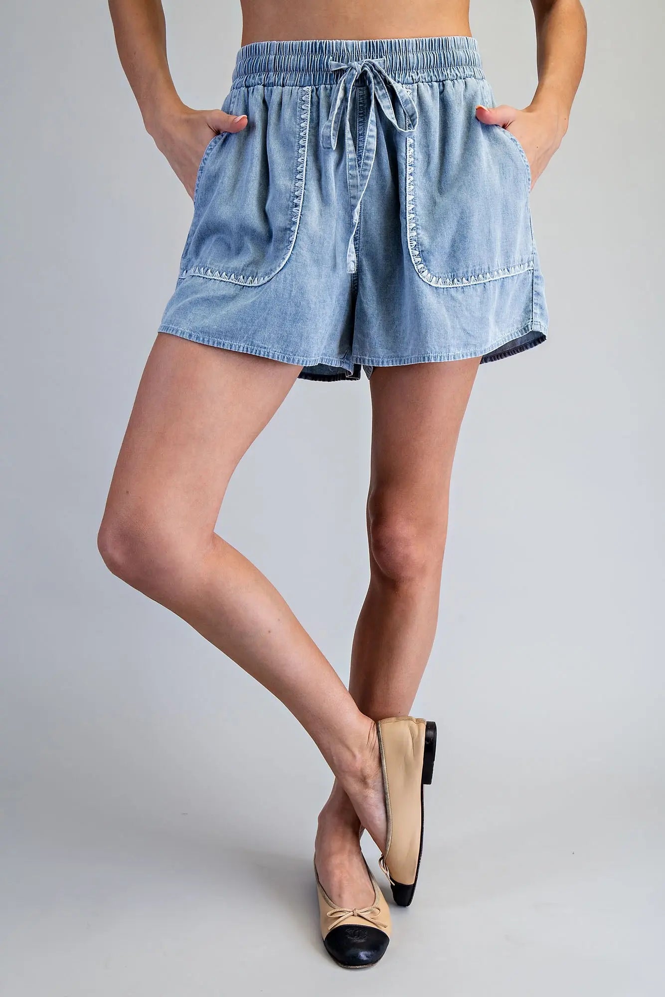 Snow washed drawstring shorts with zigzag trim pocket detail and relaxed fit, styled for a casual everyday look.