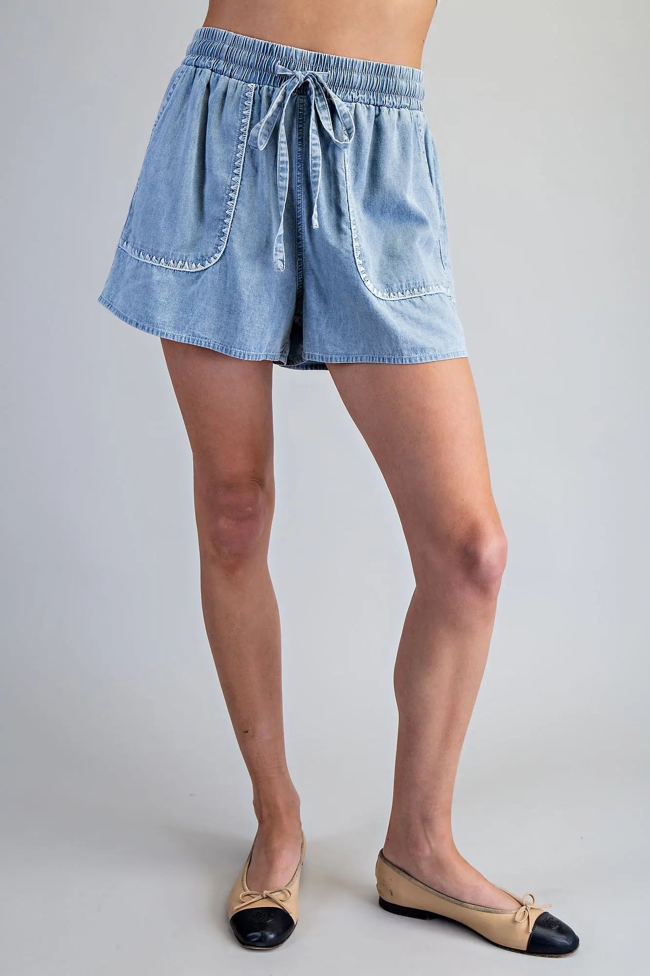 Snow washed drawstring shorts with zigzag trim pocket detail and relaxed fit, styled for a casual everyday look.