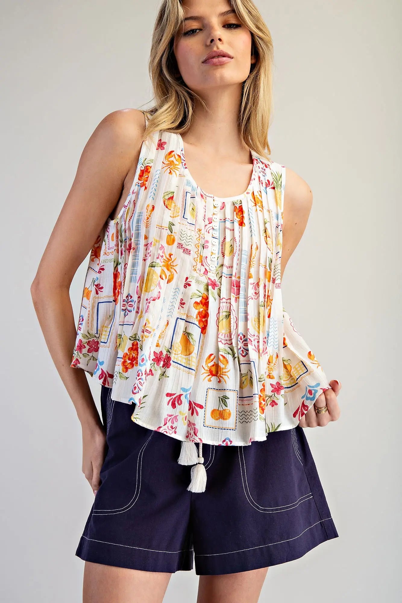  Pleated Blouse features a vibrant fruit and floral patchwork print with soft pleating and a breezy swing 