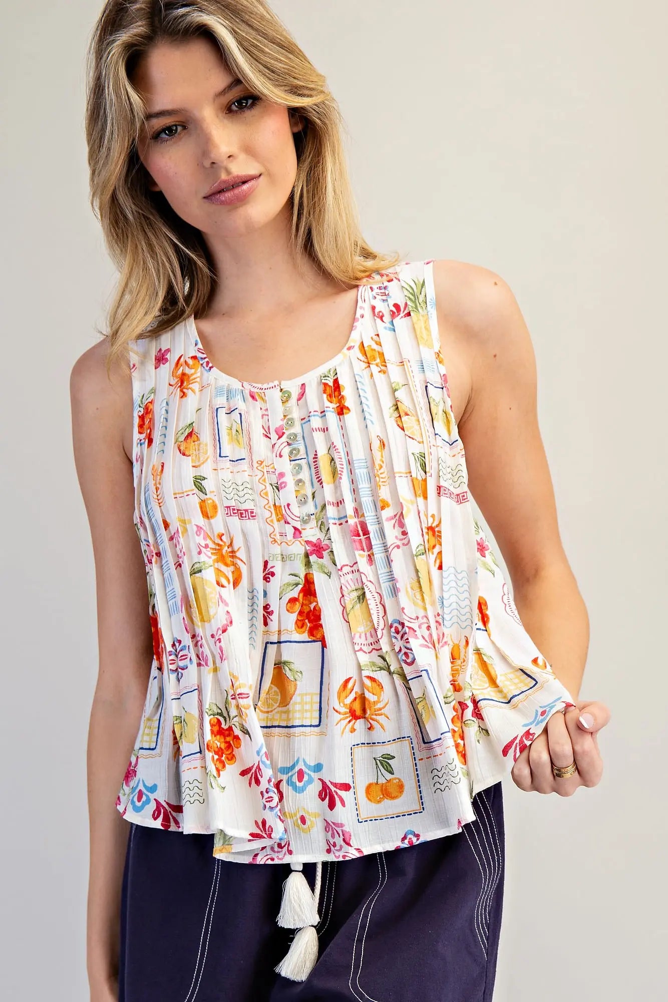  Pleated Blouse features a vibrant fruit and floral patchwork print with soft pleating and a breezy swing 