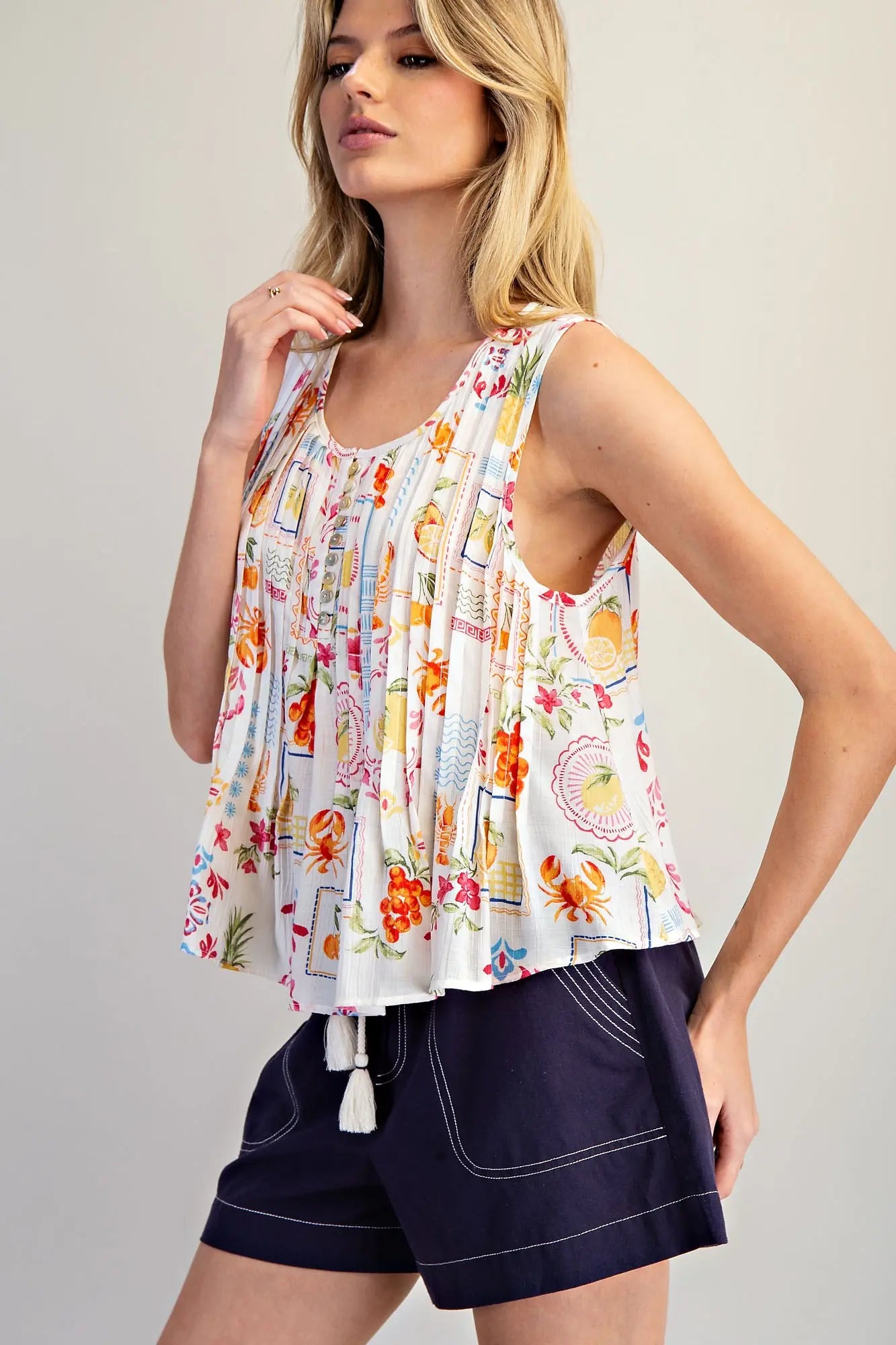  Pleated Blouse features a vibrant fruit and floral patchwork print with soft pleating and a breezy swing 