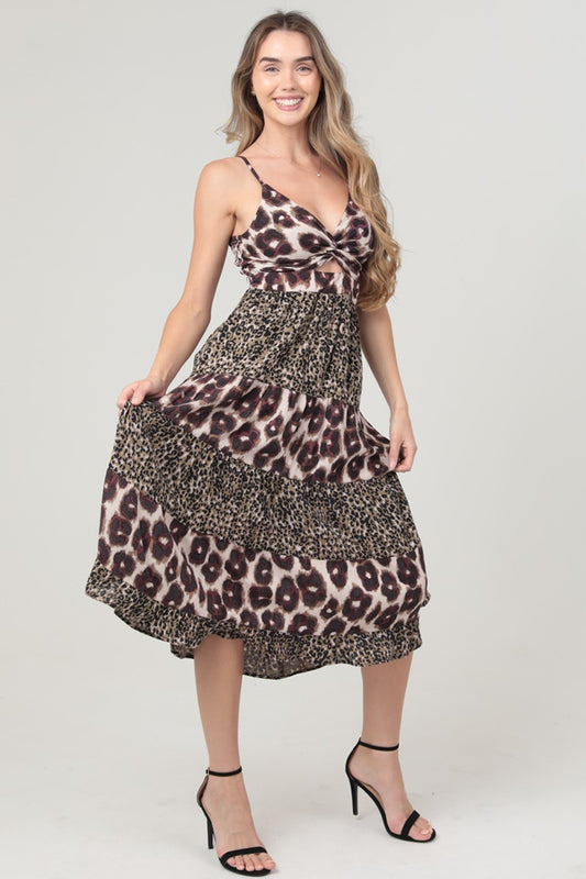 A bold mixed animal print midi dress with a twist-front bodice and striking waist cut-out.