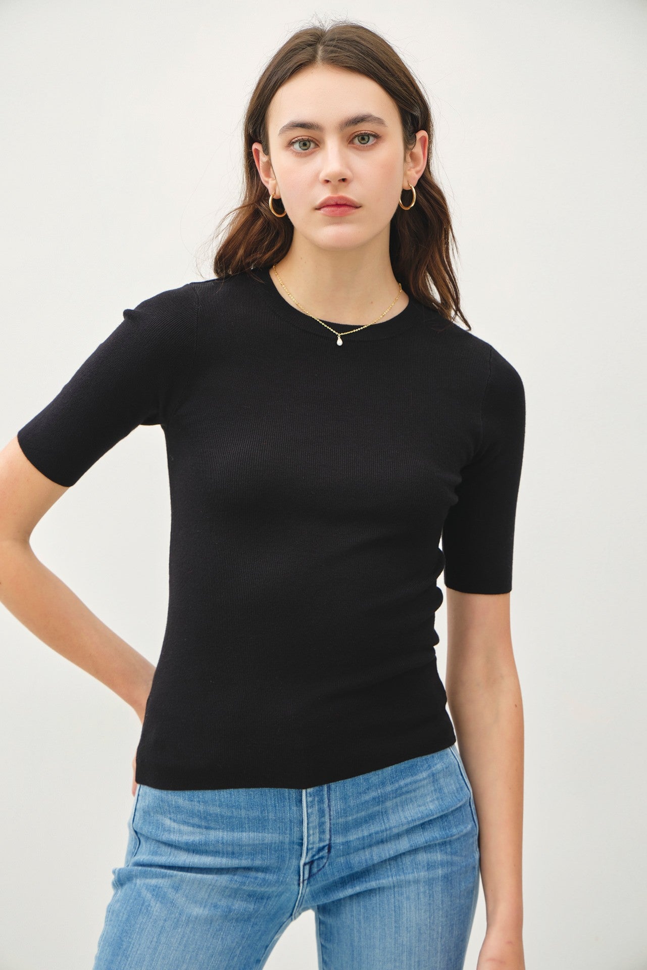 A classic ribbed knit top with a fitted silhouette and crew neckline—your go-to for sleek, effortless layering.