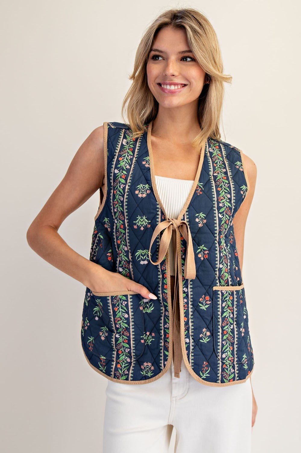 A floral-quilted cotton vest with pink contrast trim and a sweet front-tie finish.