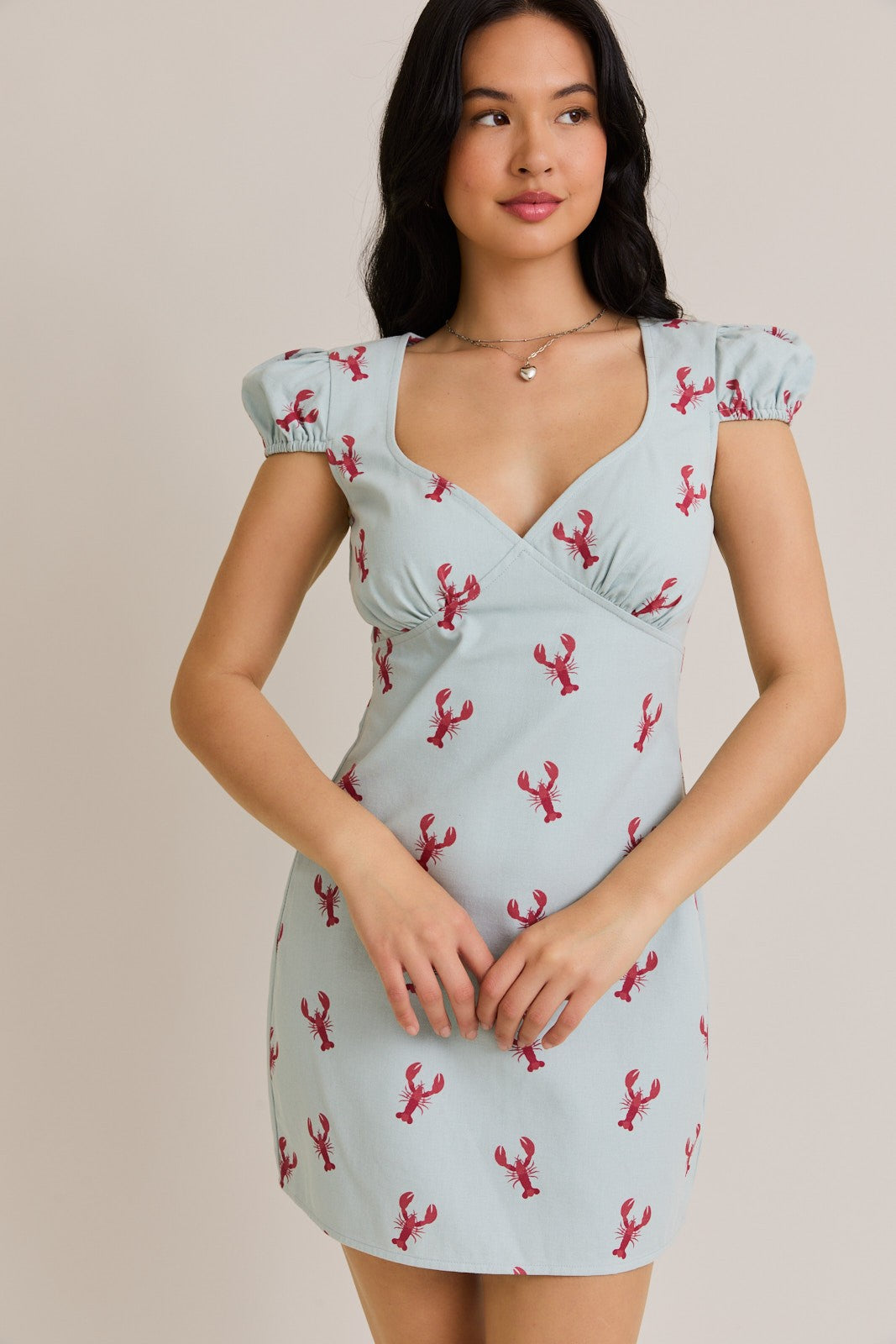 A playful cap sleeve mini dress with a lobster graphic and flattering V-neckline—perfect for fun-in-the-sun style.