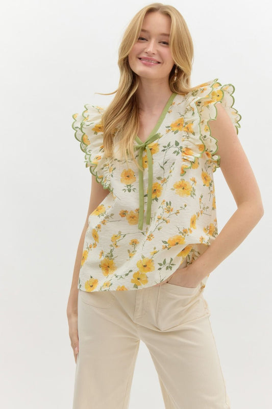 A romantic floral pullover top with sweet bow detail and layered scallop-embroidered ruffles.