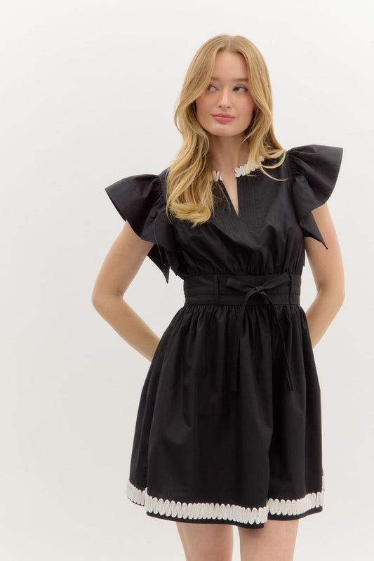A romantic flutter sleeve mini dress with elegant applique detail and a flattering smocked back.