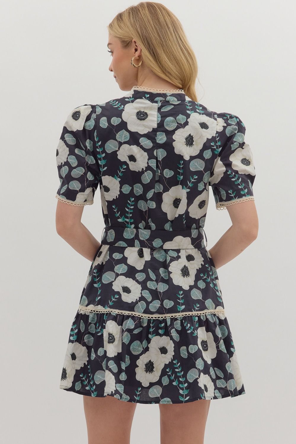 A sweet floral mini dress with contrast trim, functional buttons, and a removable belt for versatile styling.

