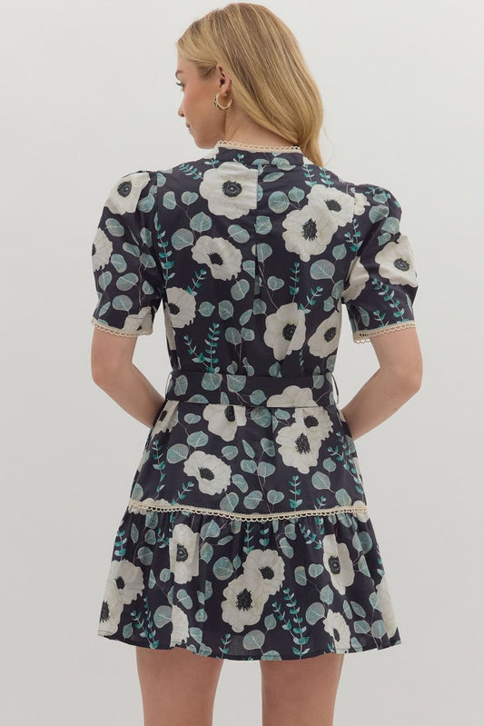 A sweet floral mini dress with contrast trim, functional buttons, and a removable belt for versatile styling.

