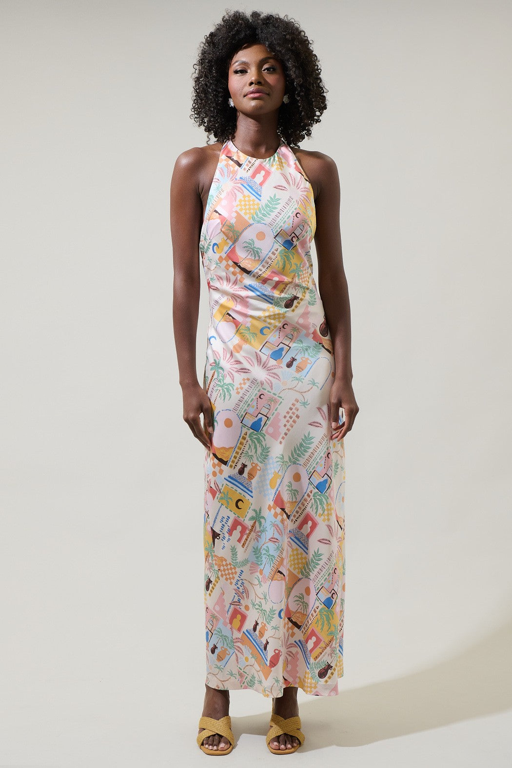 A vibrant halter midi dress with an open back and dreamy sunset-inspired print.
