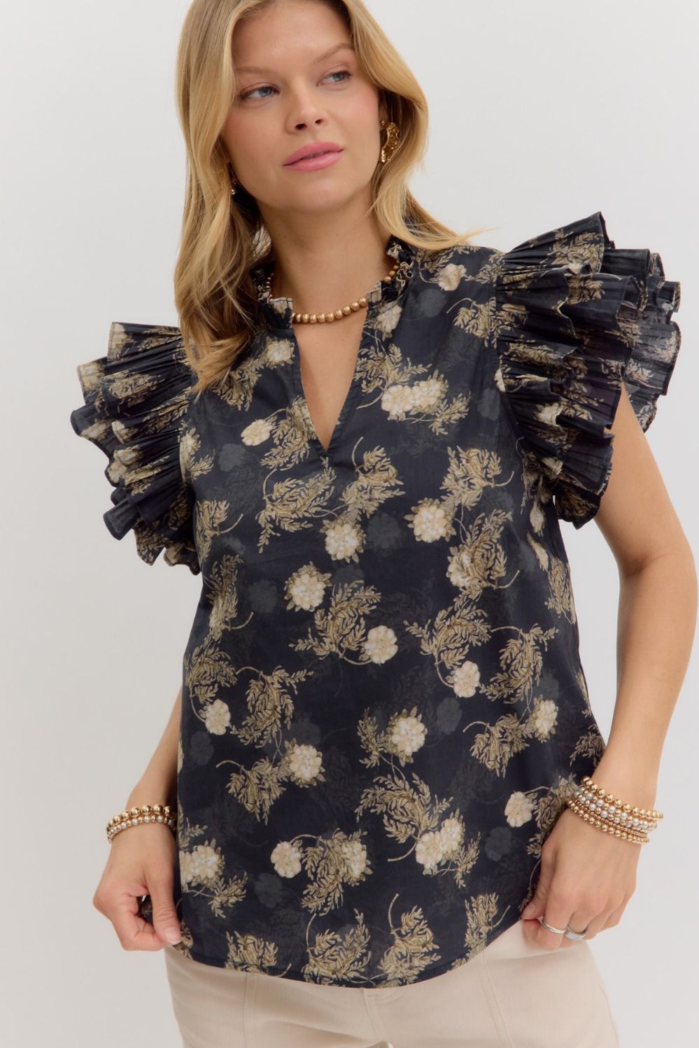 A vintage floral top with pleated ruffle sleeves and a soft, romantic silhouette.
