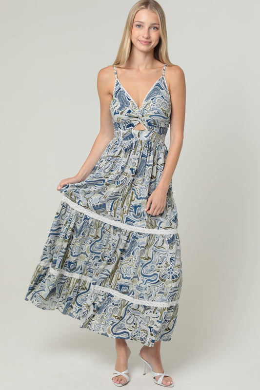 An elegant maxi dress featuring a V-neck, twist-front bodice, cut-out waist, and delicate lace trim.

