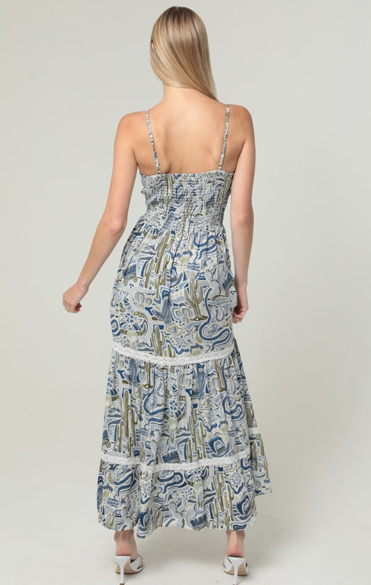 An elegant maxi dress featuring a V-neck, twist-front bodice, cut-out waist, and delicate lace trim.

