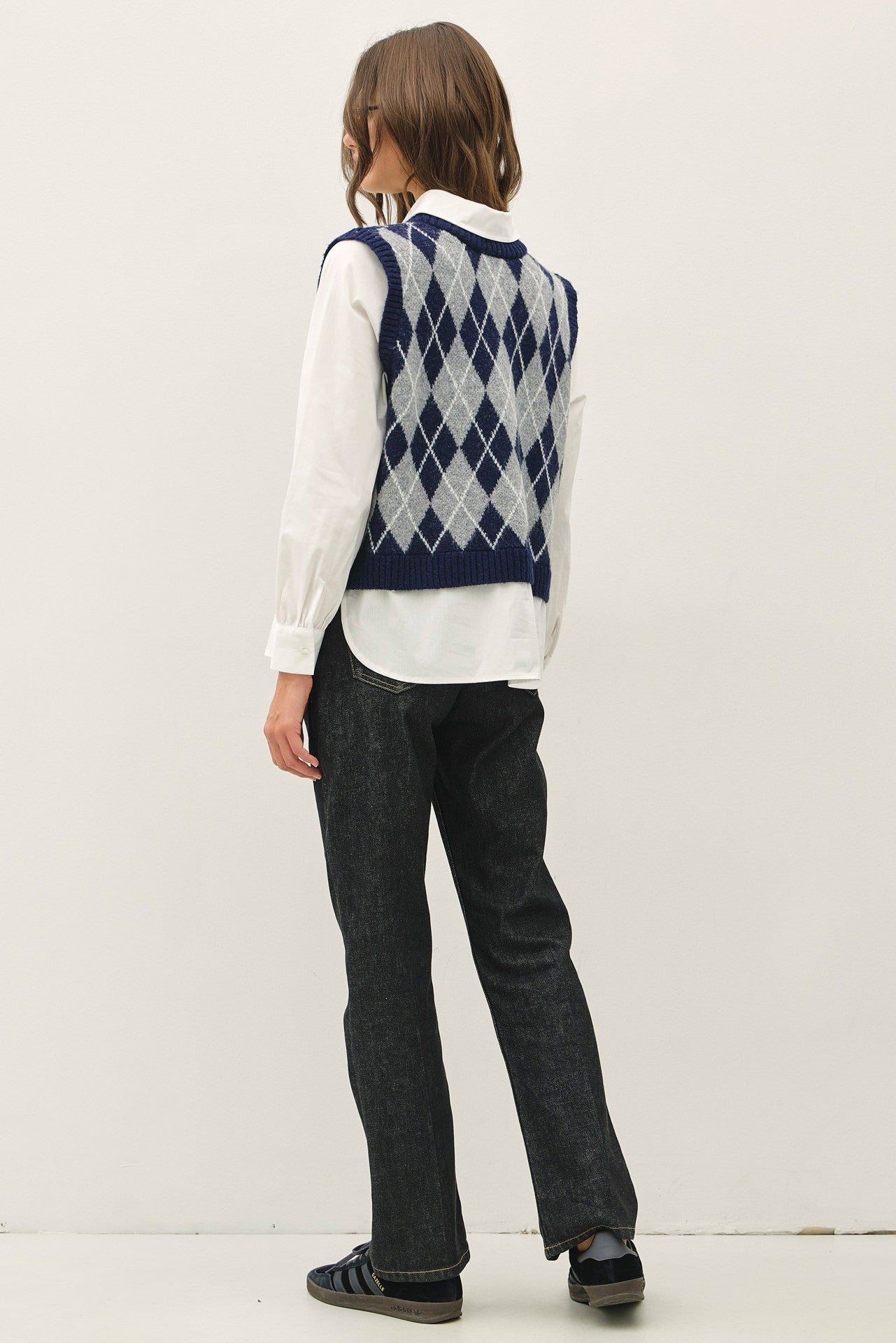 back navy and white argyle knit sweater vest over white collared shirt, that is attached to the vest 