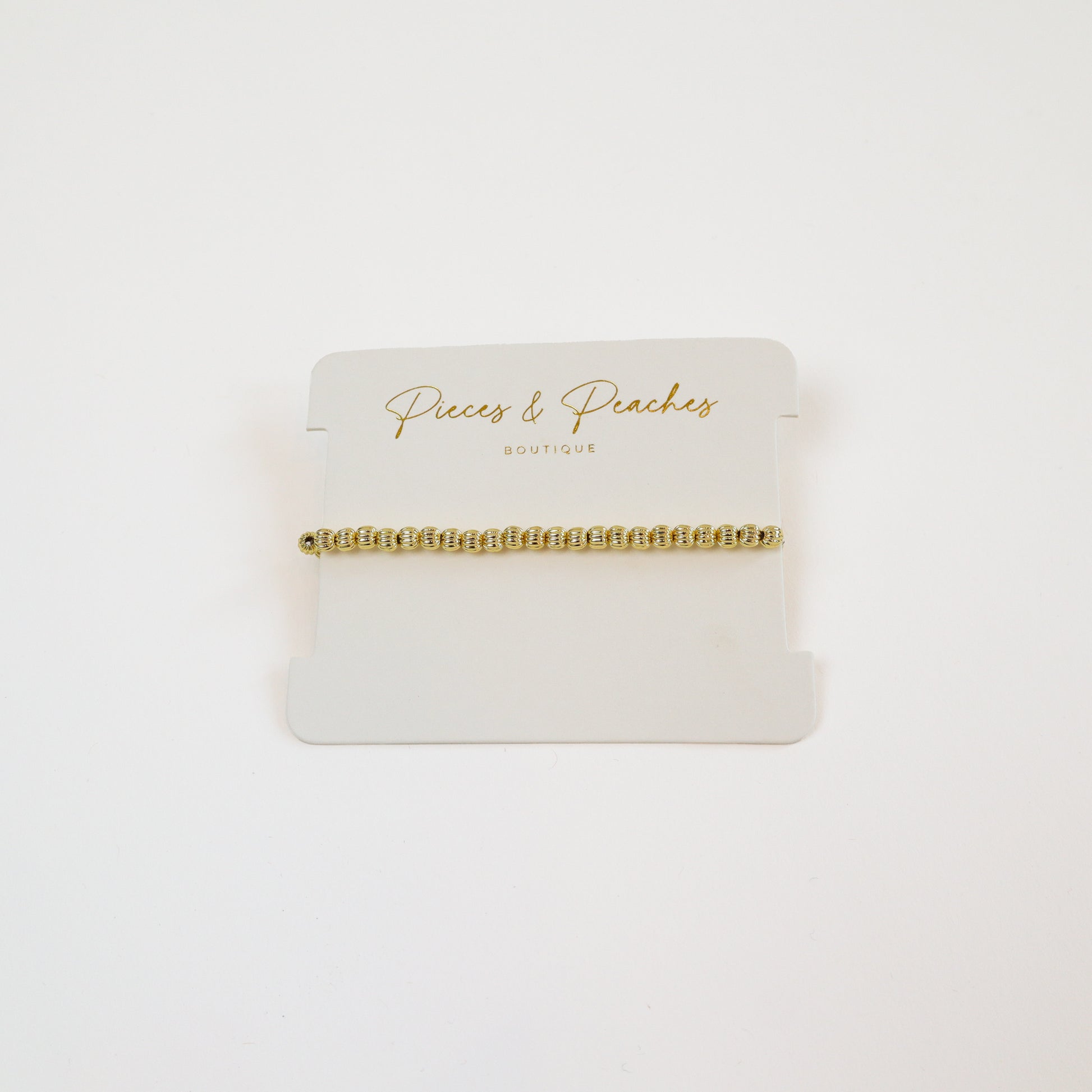 14k gold-filled textured beaded bracelet on wrist" | "Minimalist gold bracelet on white background