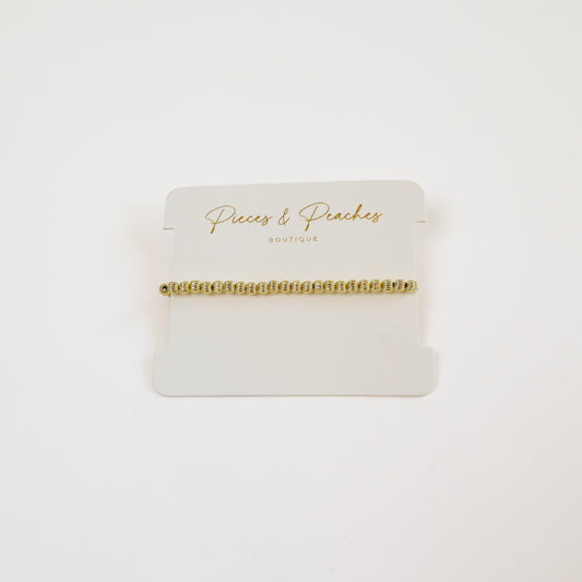 14k gold-filled textured beaded bracelet on wrist" | "Minimalist gold bracelet on white background