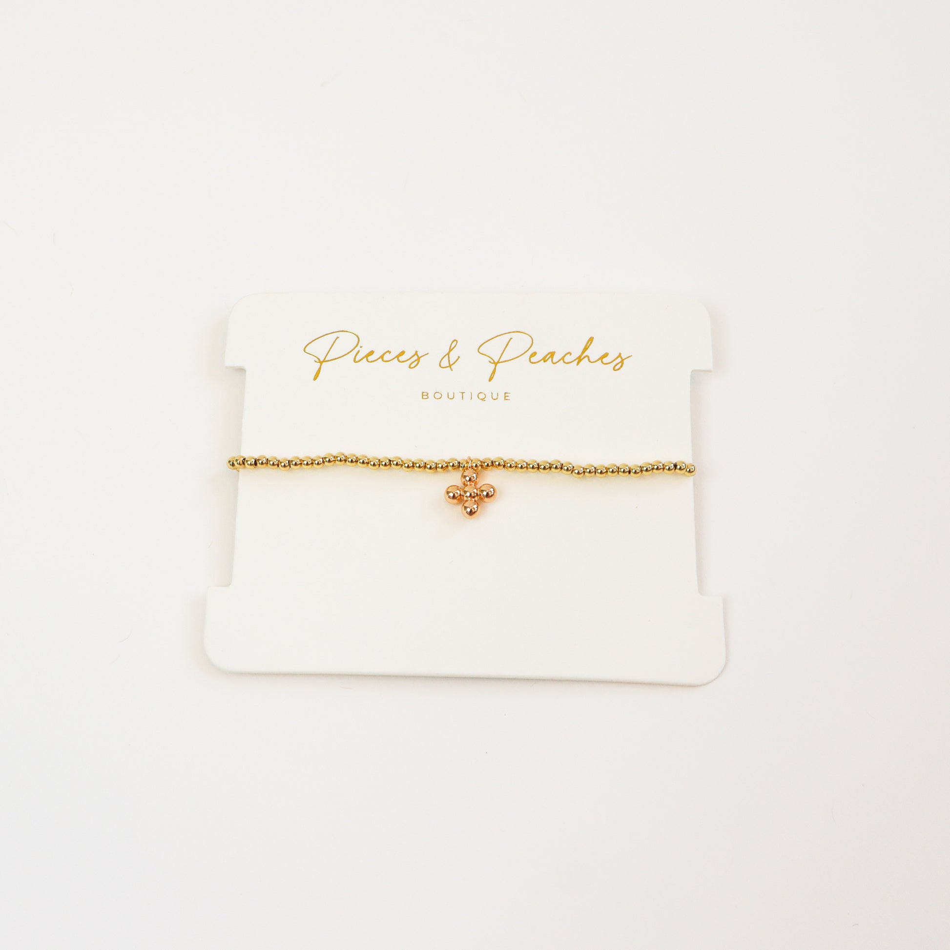 A minimal 4K gold-plated beaded bracelet adorned with a tiny ball bead cross charm for a dreamy, everyday look.

