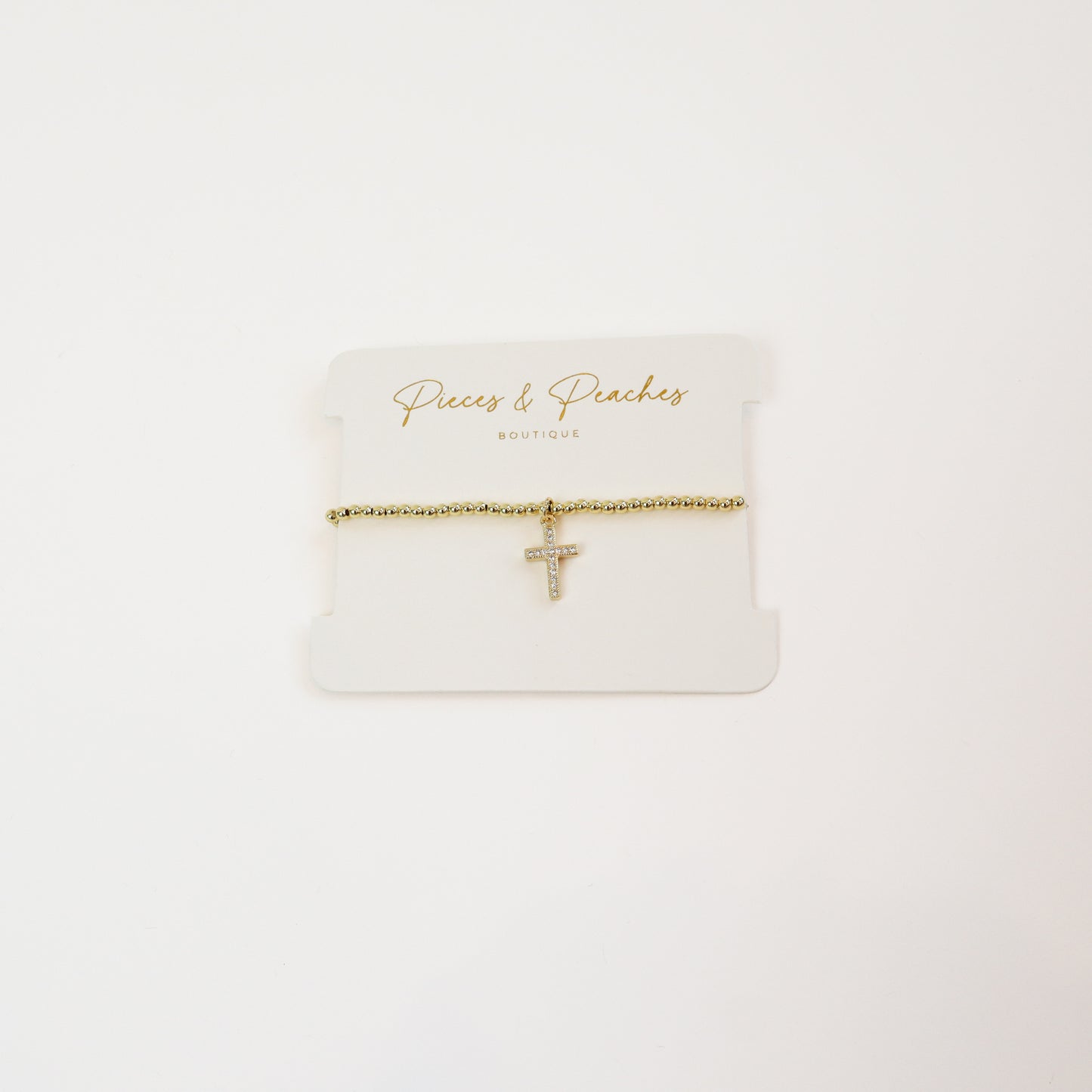 A timeless 14K gold-plated beaded bracelet featuring a minimalist cross charm for a touch of faith and elegance.
