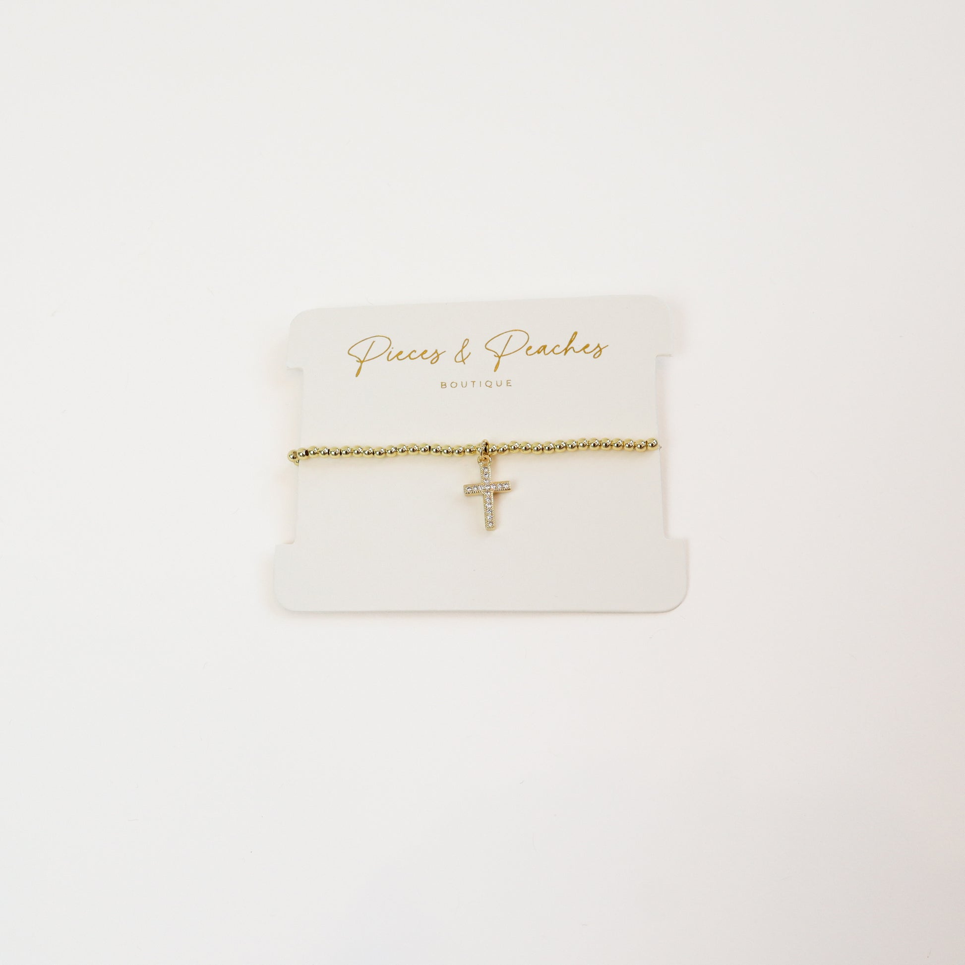 A timeless 14K gold-plated beaded bracelet featuring a minimalist cross charm for a touch of faith and elegance.
