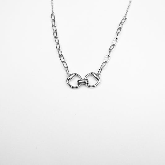 A sleek silver-tone necklace with an interlocking belt buckle pendant, perfect for a modern and minimalist aesthetic.
