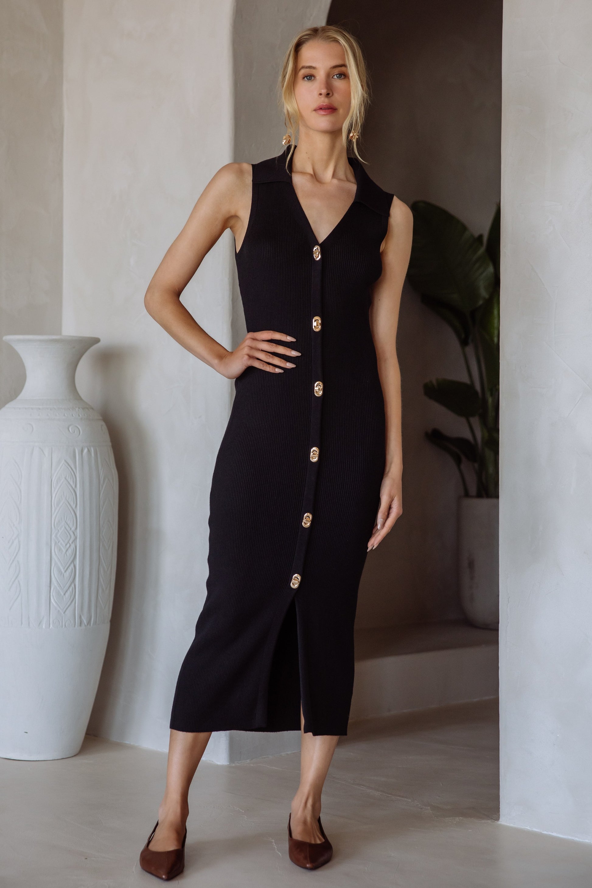 The Leona Dress blends timeless elegance with modern sophistication. Designed with a sleeveless cut and midi length, it features luxe gold twist lock buttons down the front for an eye-catching detail. Its soft, body-skimming knit drapes beautifully, making it perfect for dinner dates, work events, or polished weekend wear.

