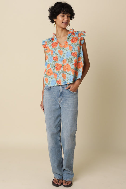 Model wearing a light blue floral ruffle-sleeve women’s top with orange and blue flowers, relaxed fit, and V-neckline