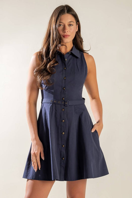 A navy blue sleeveless button-down dress with a collared neckline, waist belt, and fit-and-flare silhouette, featuring functional side pockets for an effortlessly stylish and versatile look.