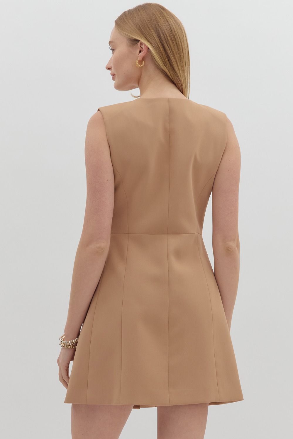 Chic sleeveless mini dress with gold buttons and flap pockets—your next game day essential.

