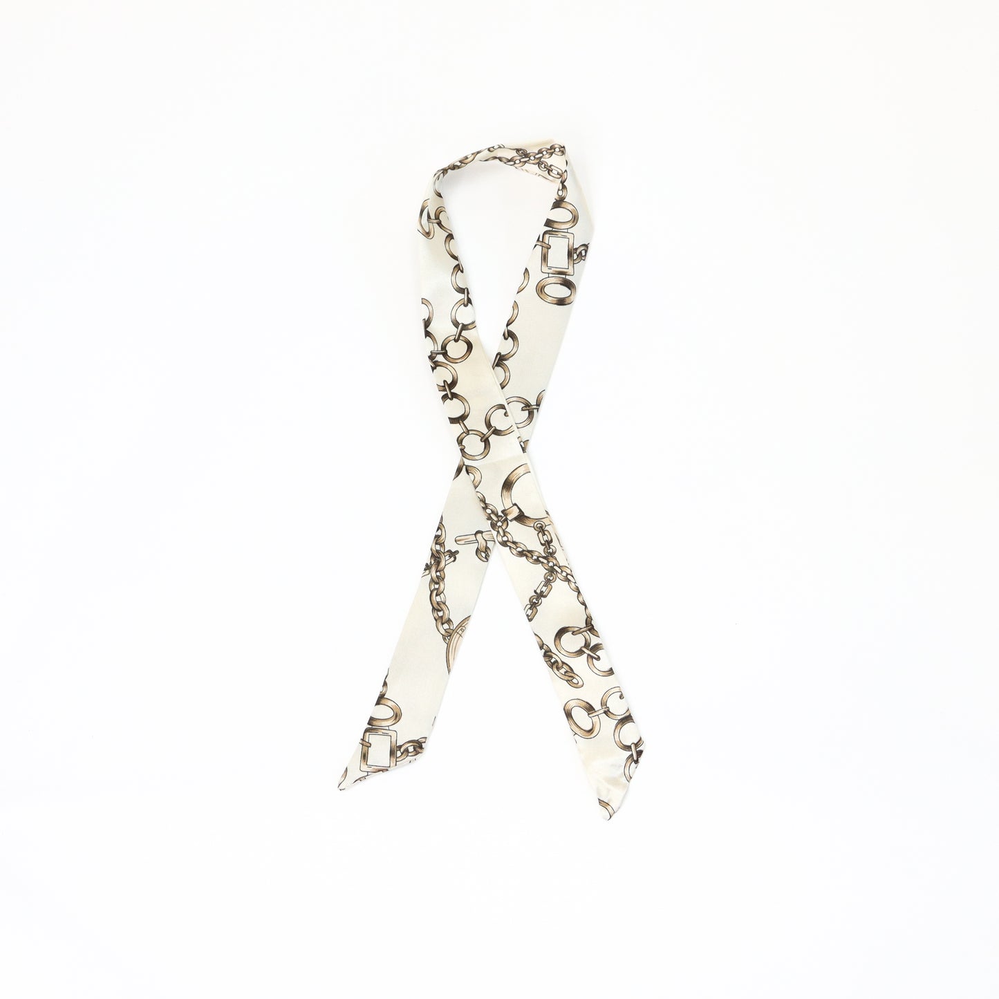 A cream-colored twilly scarf featuring an elegant gold chain pattern, styled in a loop.