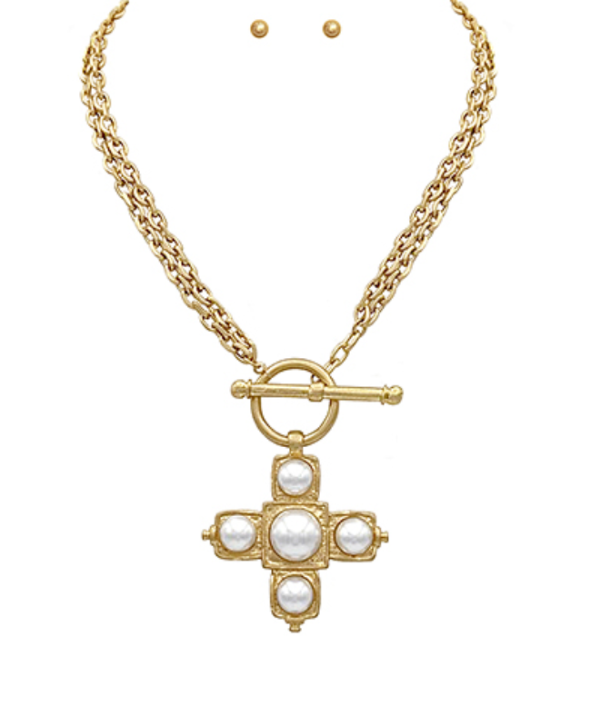 Gold toggle chain necklace with pearl cross pendant featuring a front clasp and luminous pearl accents